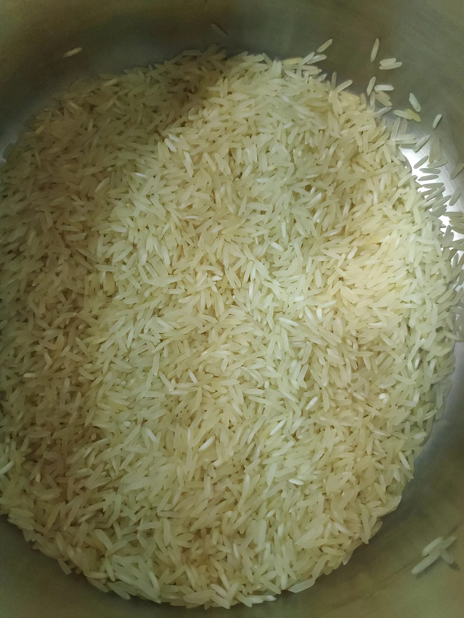 Uncooked basmati rice grains in a steel container